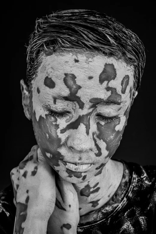 a person covered in paint with their face painted black and white