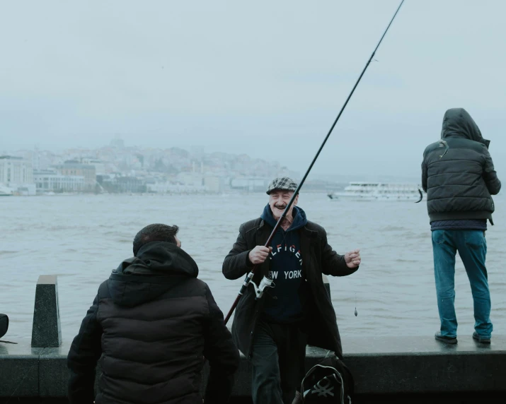 two men fishing off the water from a dock