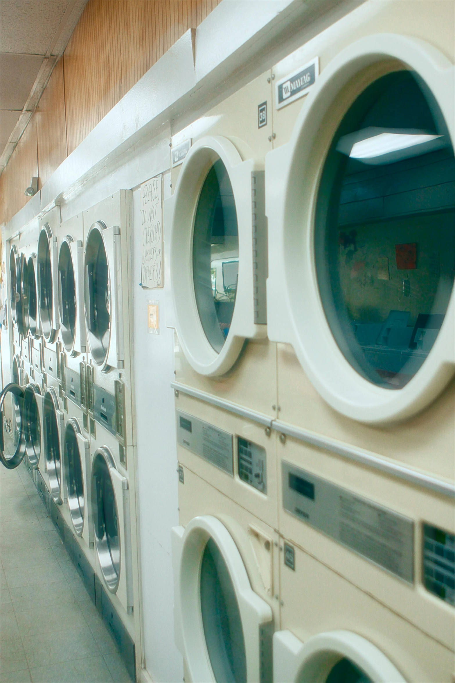 a large laundry room with a bunch of dryers on the wall