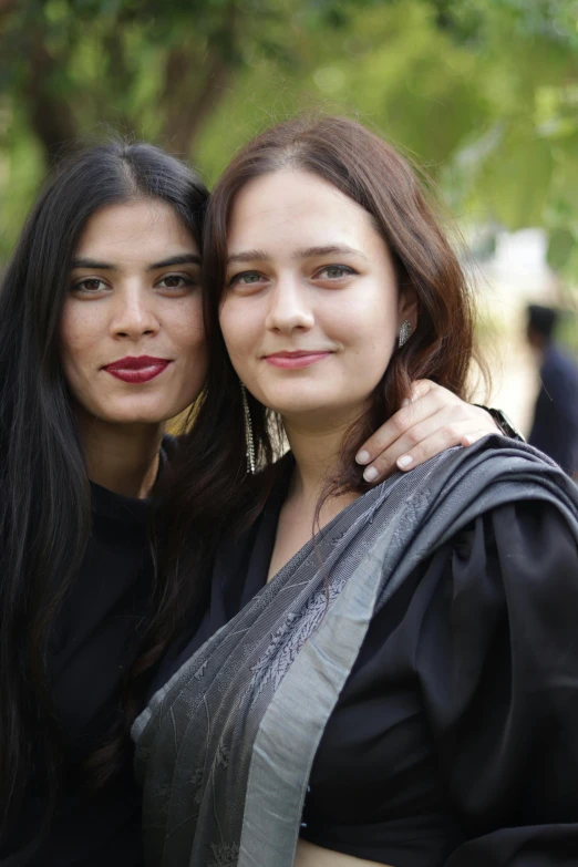 two women with long dark hair posing for the camera