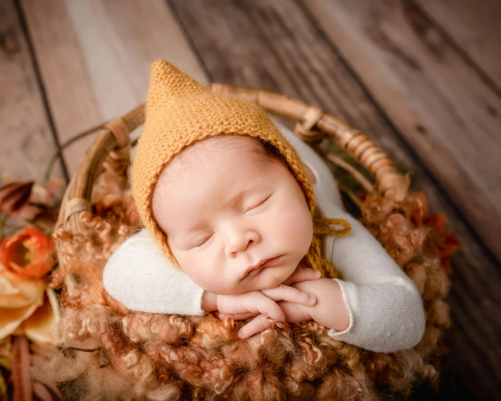 a baby is asleep in a basket with his head propped up