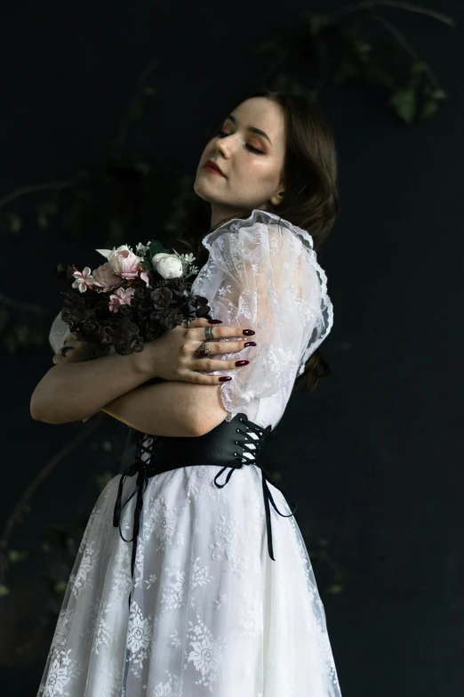 a woman in white and black dress holding flowers