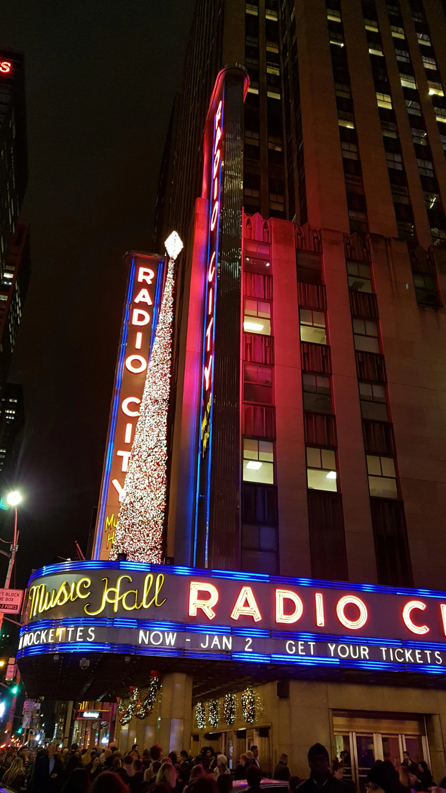 people standing in front of radio city music hall