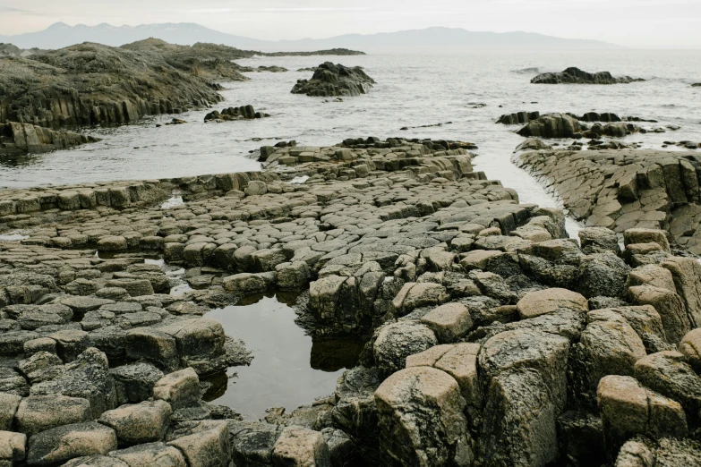 there are many rocks and water on the shore