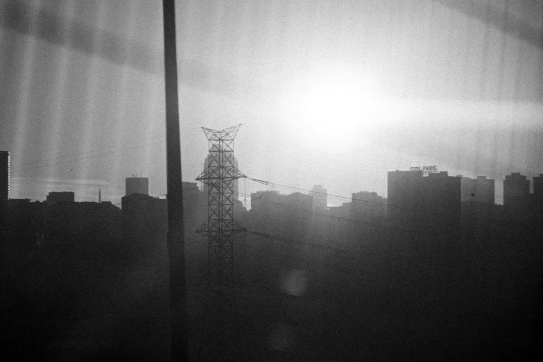 the sun is setting over a city in black and white