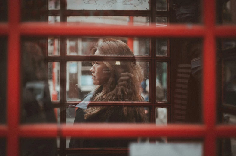 a woman stands in front of a glass door