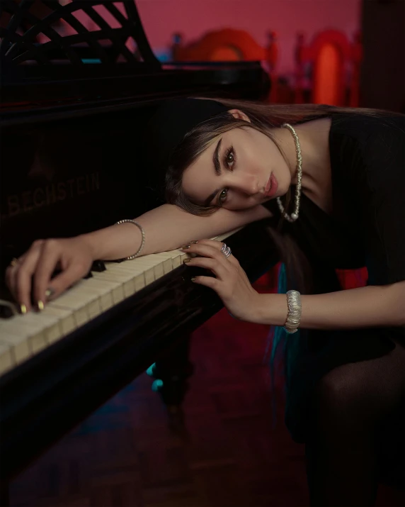 a woman leaning on top of a piano