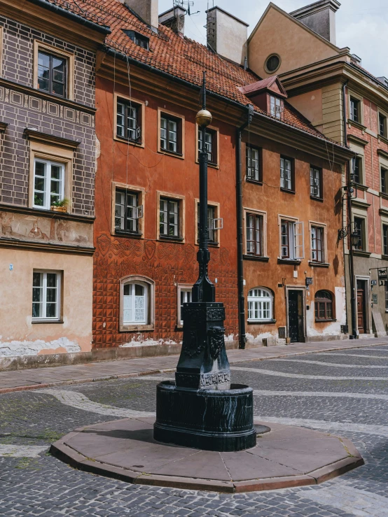 a clock with lights on in a square between two buildings