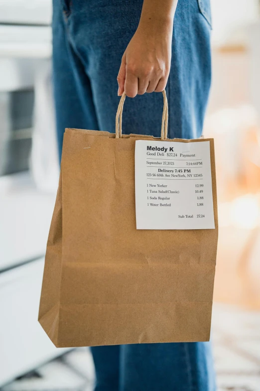 a person is holding a brown bag with information on it