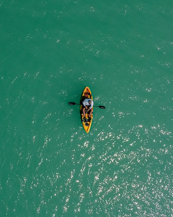 an aerial s of a man rowing a kayak