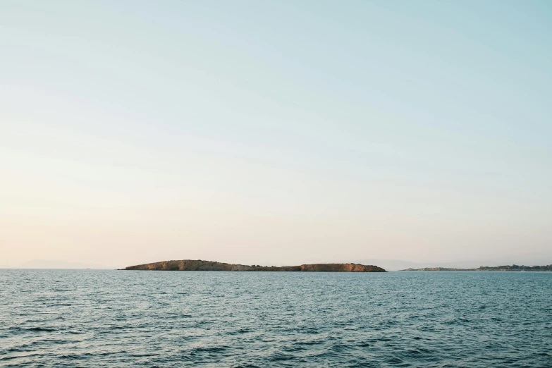 a body of water with rocks and a lighthouse in the distance