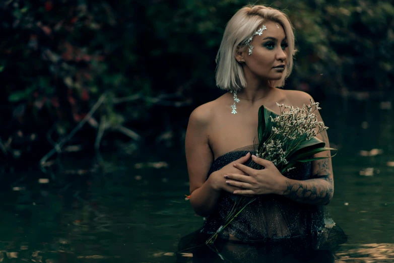 a lady in water and with green flowers