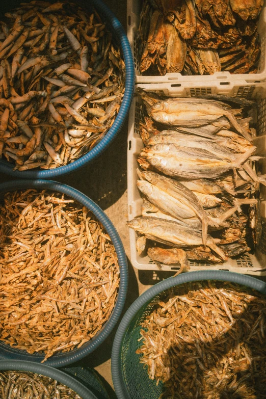 baskets full of dried fish and mussels sitting on a table