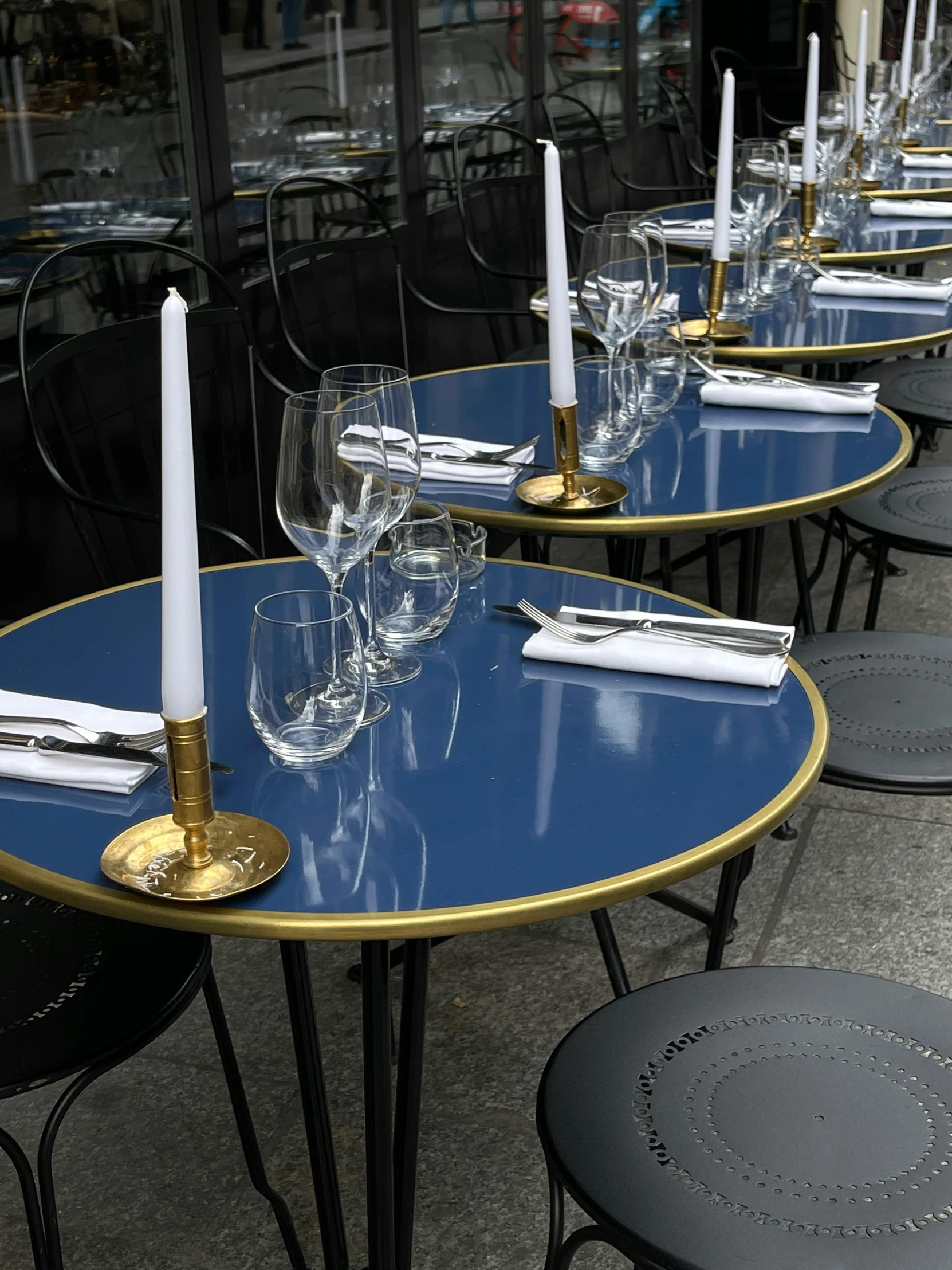 a line up of tables with wine glasses and candles