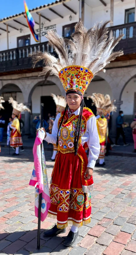 the boy is wearing a headdress and feathers on his head