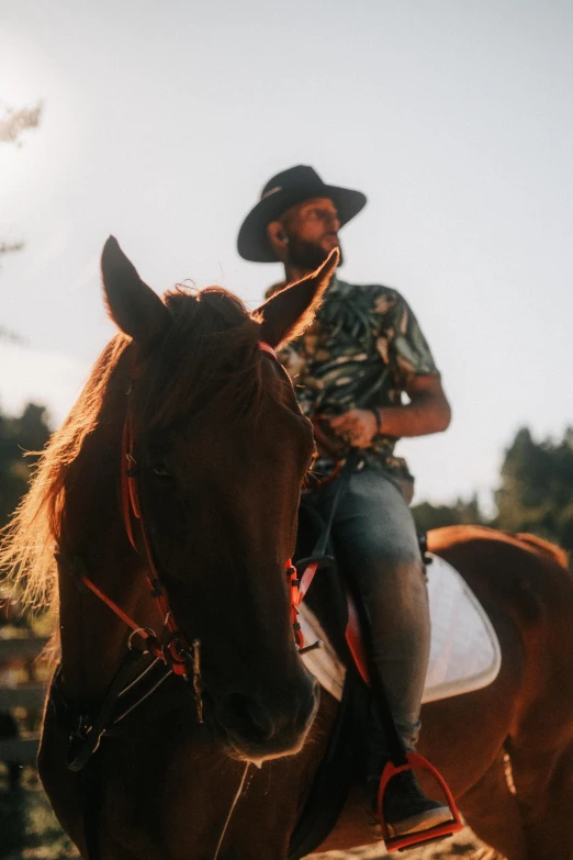 a cowboy riding a horse near a fence