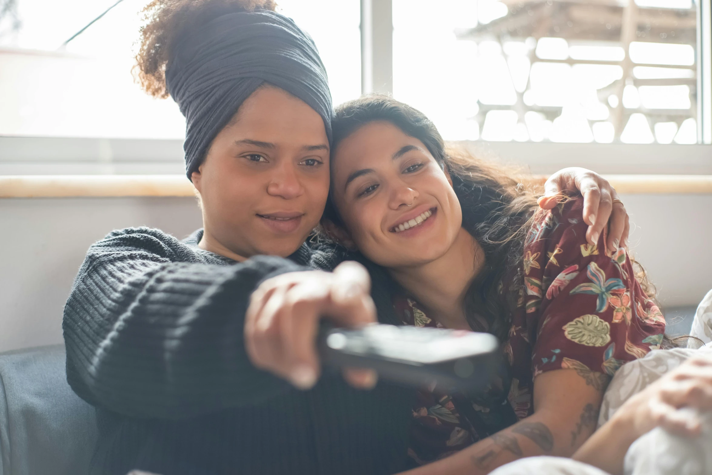 two women smile while they are holding soing