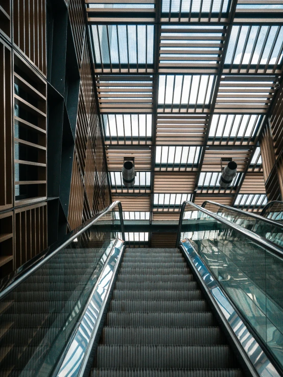 an escalator in a large building with lots of glass