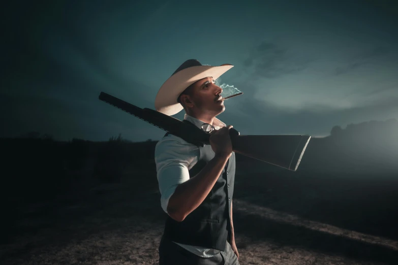 a young man in a cowboy hat holding a sgun