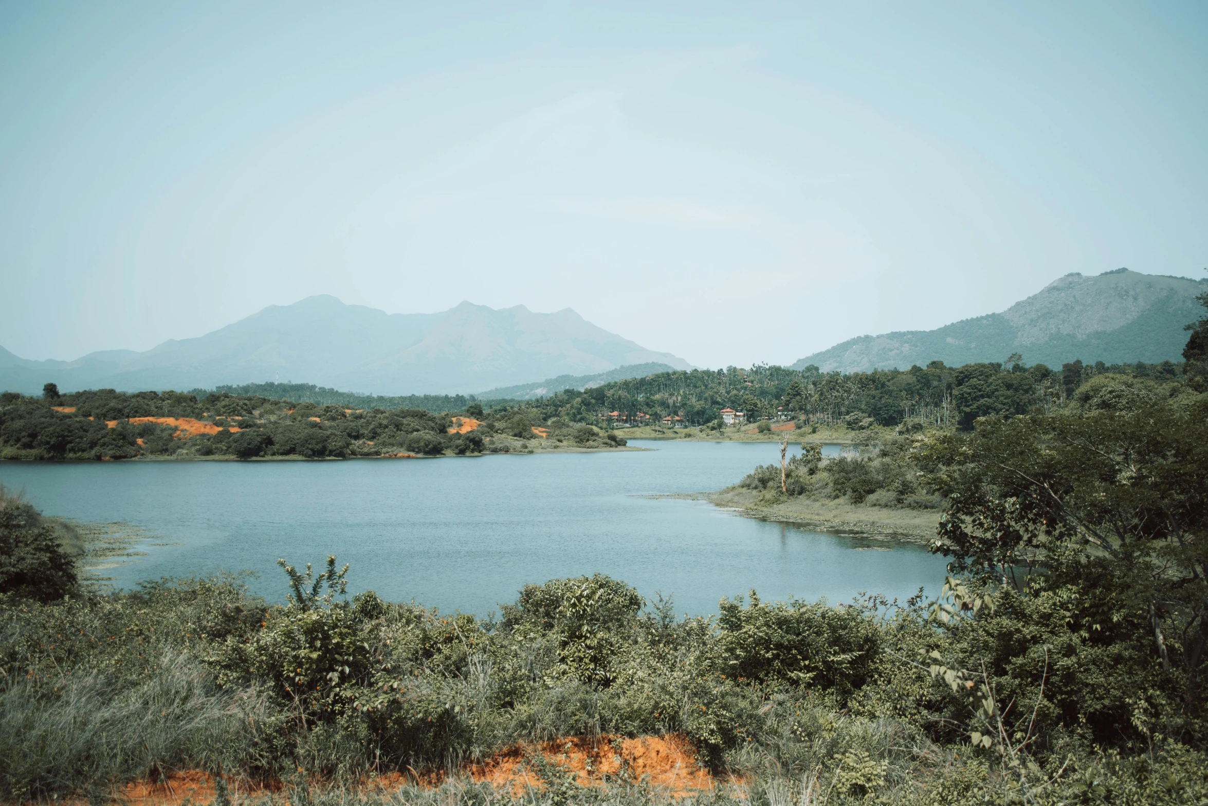 a small lake surrounded by trees and mountains