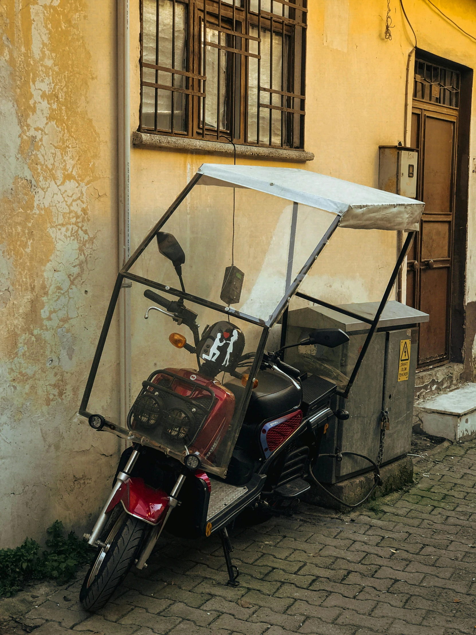 a scooter is parked on the sidewalk near a wall