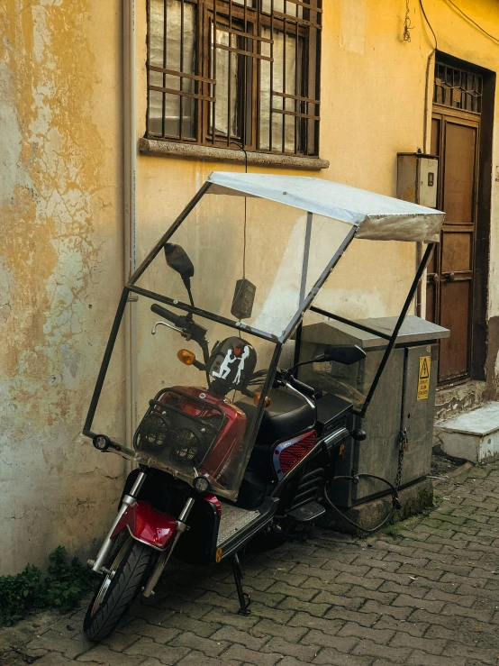 a scooter is parked on the sidewalk near a wall