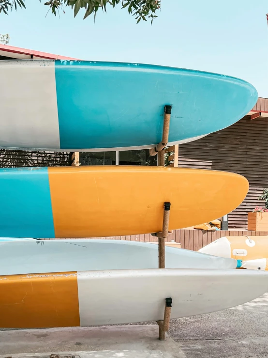 surfboards placed on top of each other behind a bench