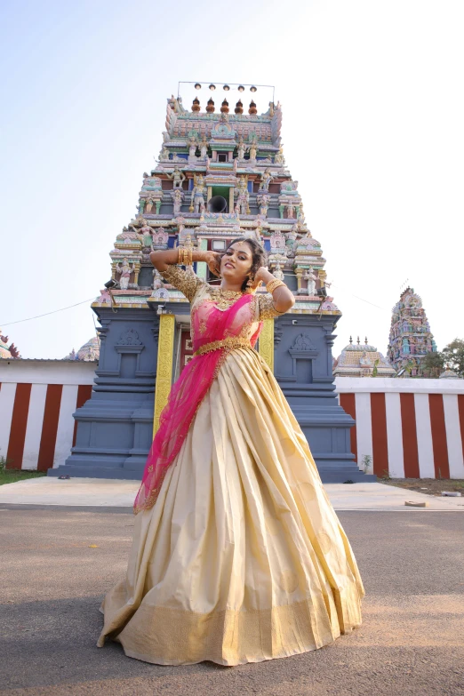 a woman in a colorful dress standing in front of a statue