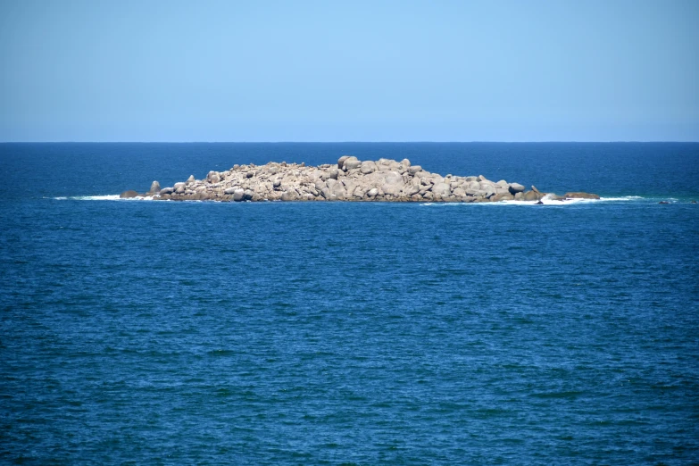 a rocky island stands on top of the water