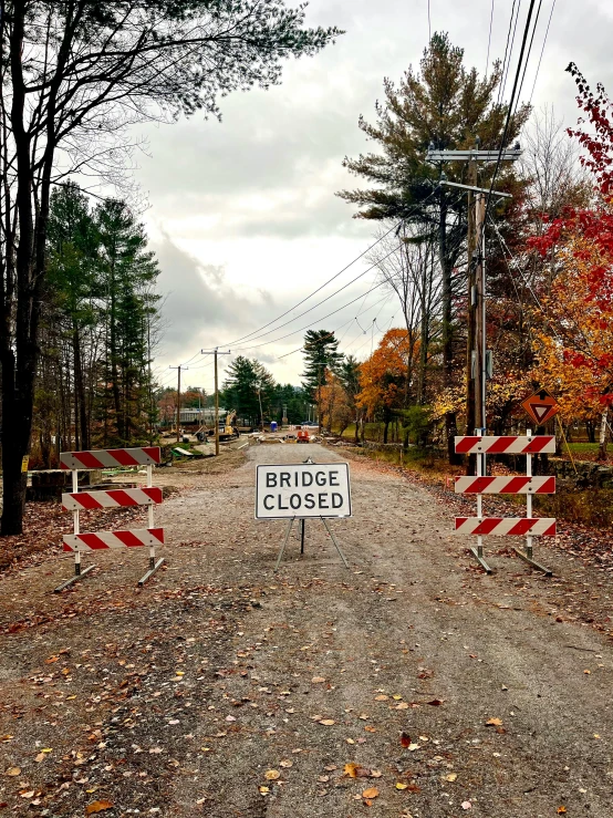 road construction signs blocking off a road on a cloudy day