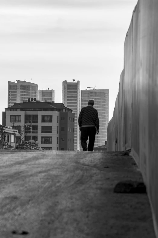 a person is walking down the road in the background are tall buildings