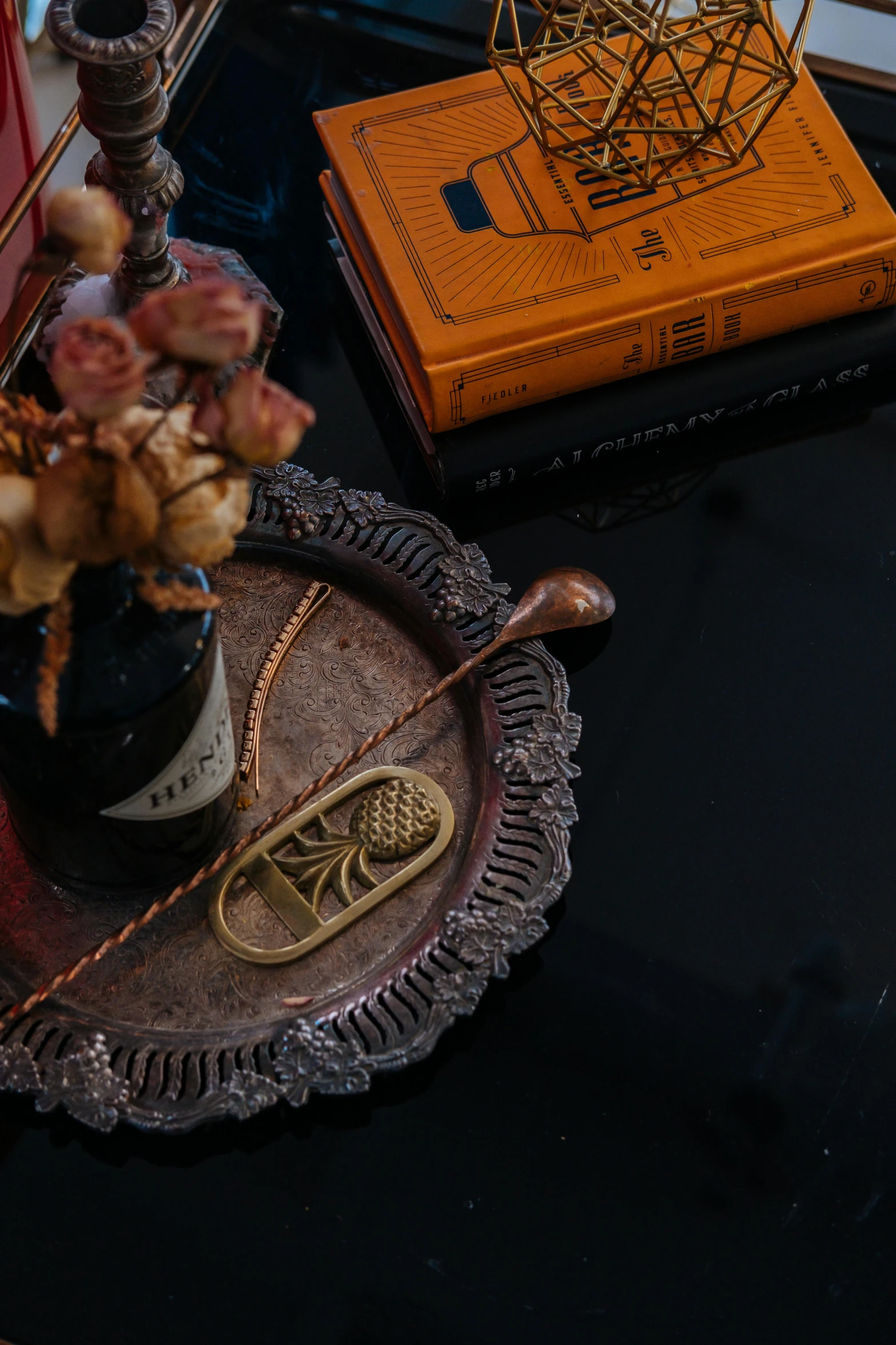 a cell phone sits on a tray next to a book and small flowers