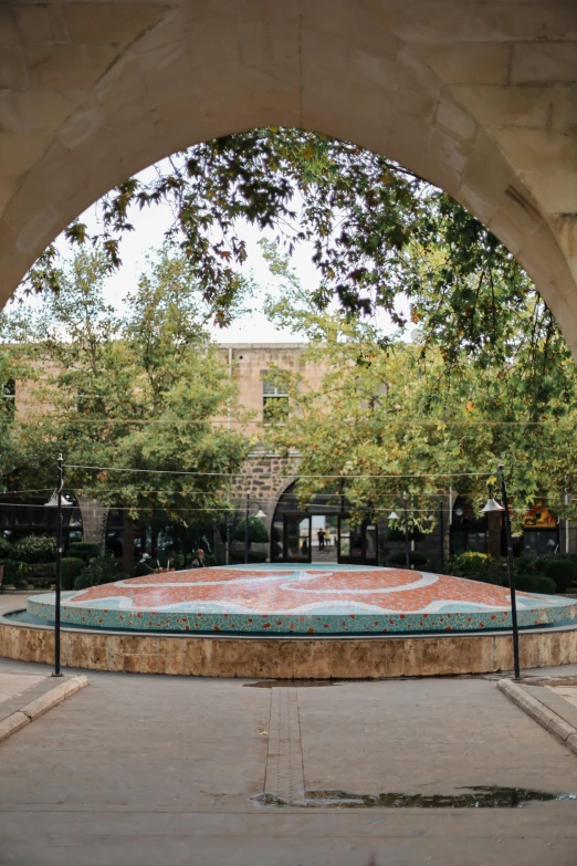 a bench sitting next to a large cement fountain