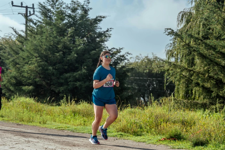 the runner is in full gear as she is crossing a street