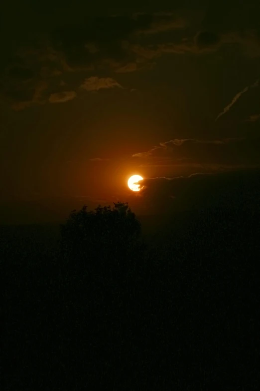 a dark sky and moon that appears to be half full