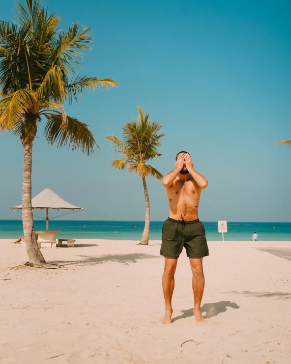 a man with  on standing on a sandy beach