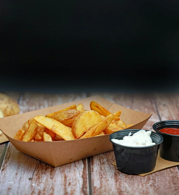 an image of some fries and sauce in a box