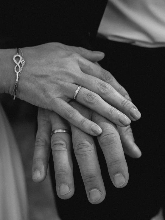 a couple holding each other's hands with rings on their fingers