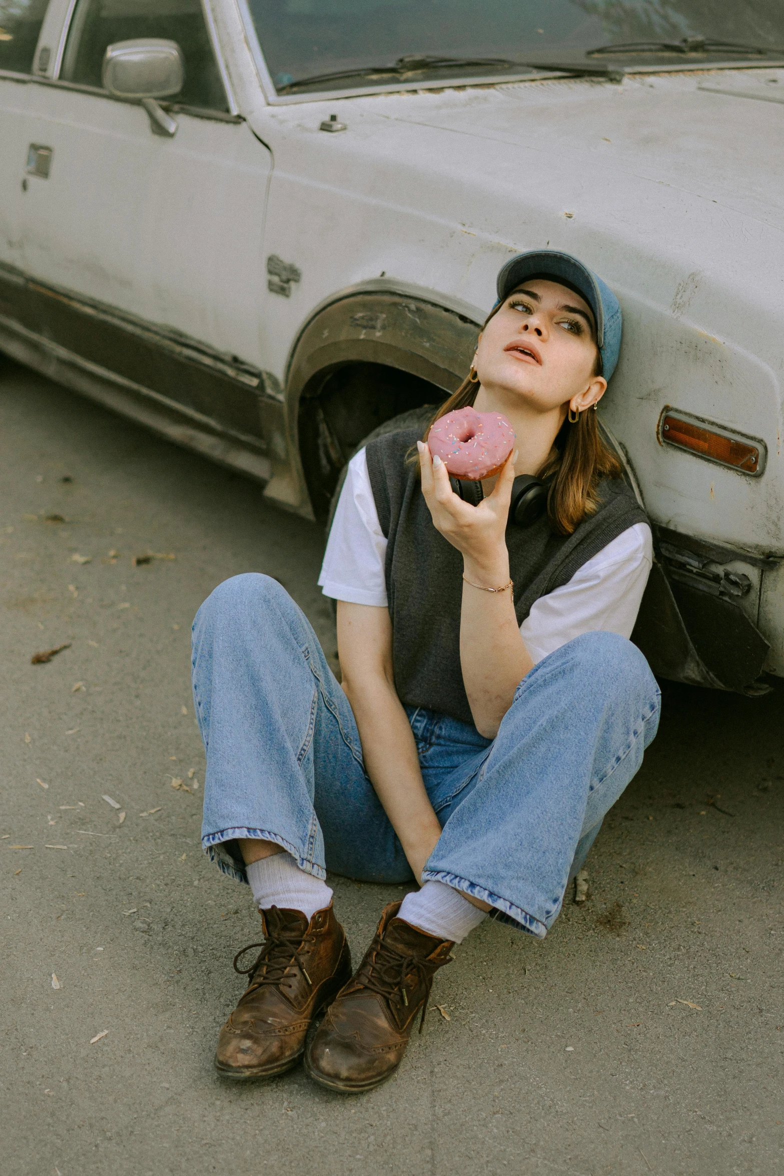 a person sitting in front of a car with a donut