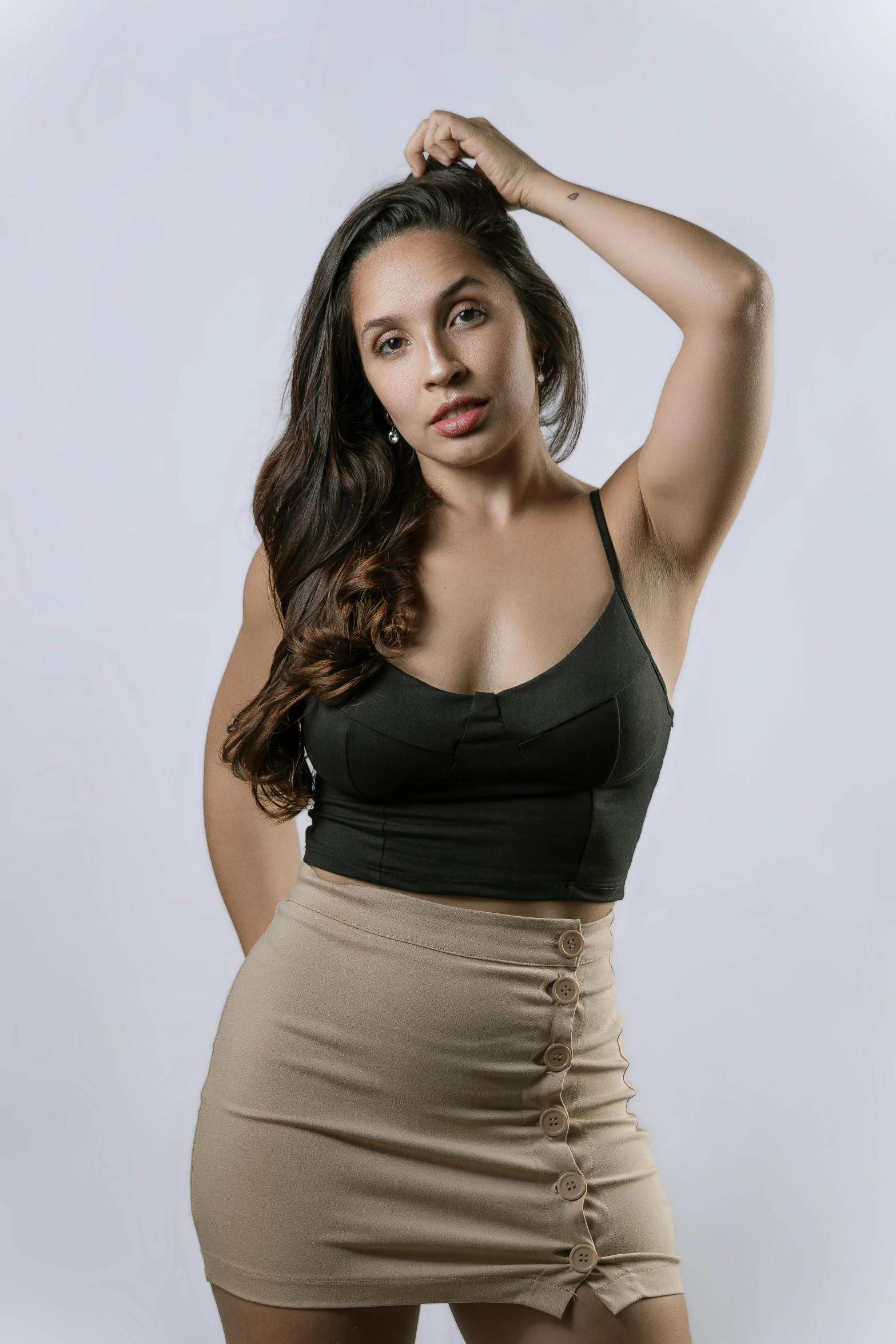 a beautiful woman posing for a po wearing a tight skirt and tank top