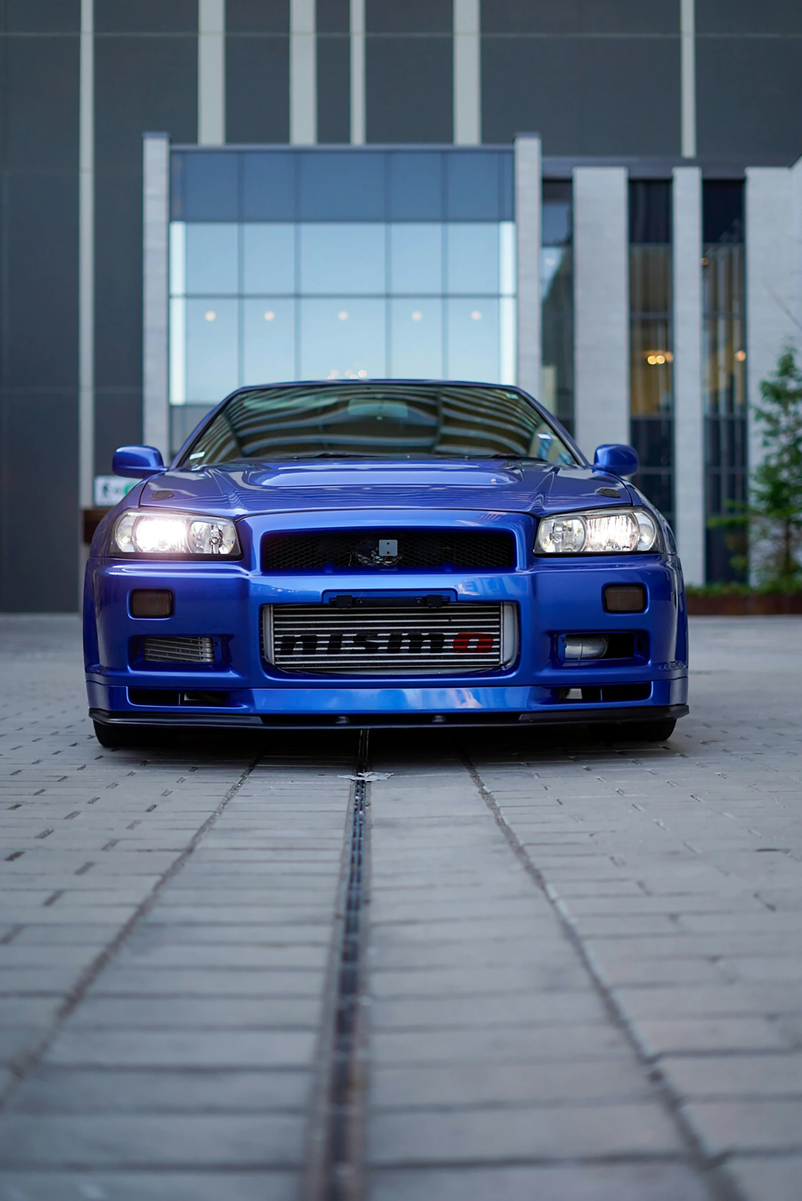 a blue sports car parked in front of a building