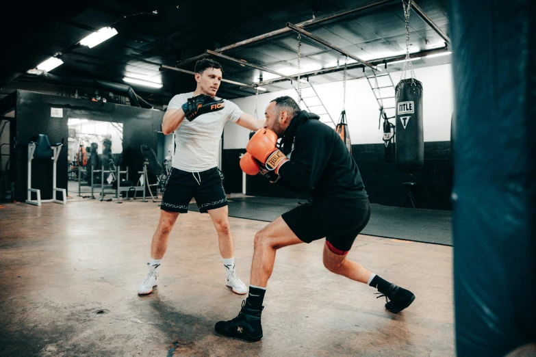 two men are playing boxing in the gym