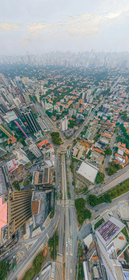 an aerial view shows city street traffic with other cityscape in the distance