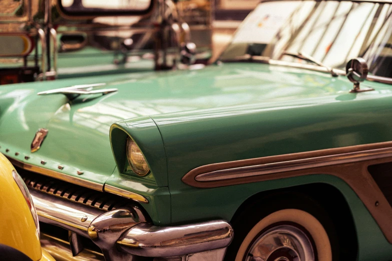 an old green pick up truck and other vehicles parked