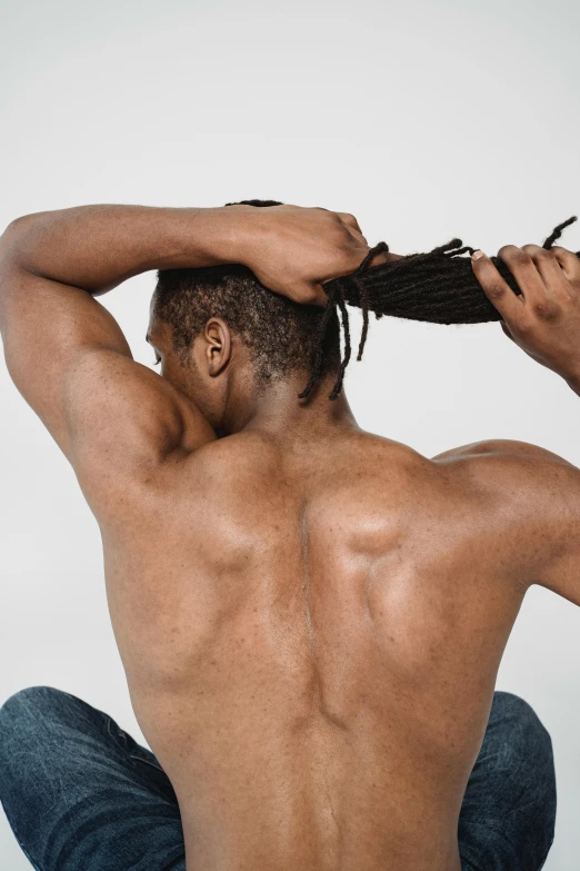 a man in blue pants and his hands on his head