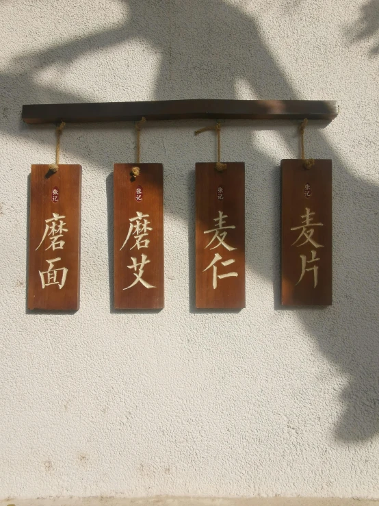 four plaques with asian writing hanging on the wall