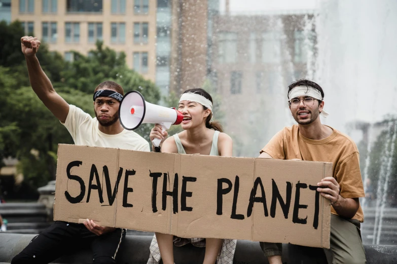 a group of people on the street holding a sign that says save the planet