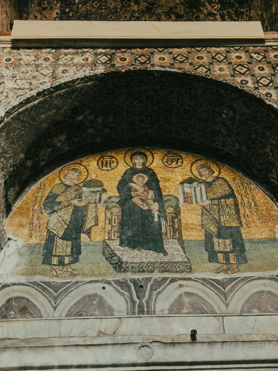 two ornately decorated murals adorn the wall behind a arched doorway