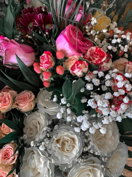 closeup of a bouquet of various flowers on top of a wood table