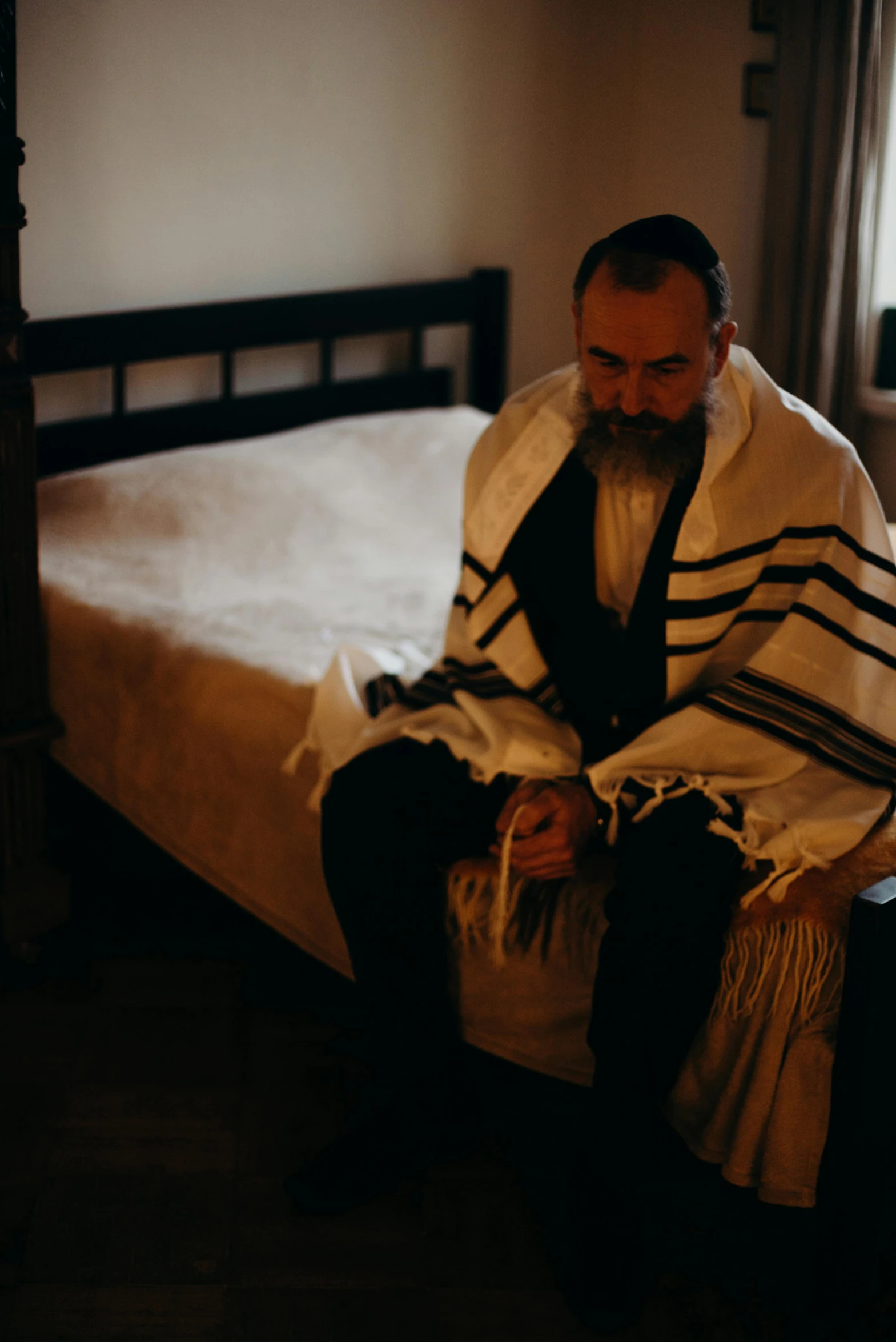 a man sitting on top of a bed in a bedroom